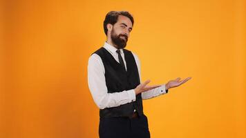 Culinary employee presents both sides of studio, working as luxurious restaurant staff member to serve consumers. Butler in suit and tie creating advertisement pointing to left or right sides. photo