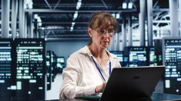 Licensed worker working in server room housing GPU dedicated supercomputers that can process AI tasks with high efficiency, patching up rigs used for machine learning showing errors photo