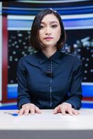Presenter on midnight news show addressing media outlets information about international events during live segment. Asian woman talking about international newscast with details. photo