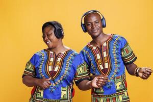 contento negro hombre y mujer Pareja disfrutando música en auriculares y imaginando a jugar guitarra. alegre africano americano biamigo y Novia vistiendo inalámbrico auriculares foto