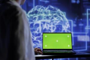 Admin using mockup device for artificial intelligence computing simulating human brain through self learning algorithms. Employee with isolated screen laptop, working with AI deep neural networks photo