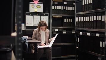 Female investigator researching information to strengthen criminal case by accessing classified data in police department. Law enforcement official uses witness background checks to catch suspect. photo