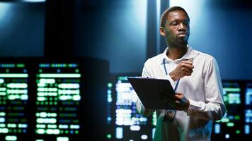 African american engineer preventing supercomputer cybersecurity issues arising due to unsecured network connections. Specialist making sure data center is invulnerable to phishing attacks photo