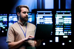 Meticulous engineer inspecting operational server rows in computer network security data center. Supercomputers providing processing and memory resources for various workloads photo