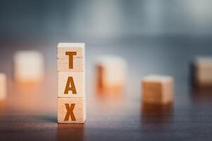 Wooden cubes with the word TAX on a desk. Business concept. photo