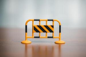 Traffic barrier on the wooden floor in front of a blurred background. photo