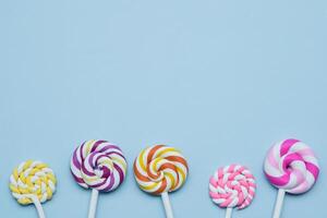 Colorful lollipops on blue background. Top view with copy space photo