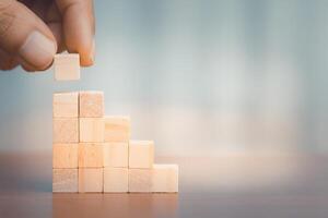 Hand arranging wooden block stacking as step stair. Business growth concept photo