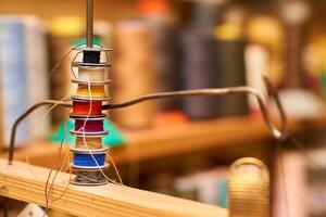 Multi colored spools of thread for a sewing machine in a tailor's workshop photo