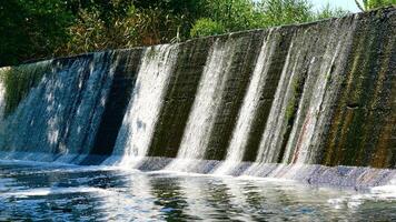 River dam with clear flowing water on a warm day photo