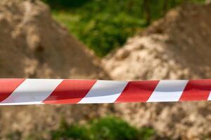 Red and white fencing tape warning of danger during construction and repairs photo