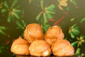 Delicious baked cakes profiteroles with cream photo