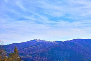 Aerial view of an autumn small village in a valley and mountains in a blue haze photo