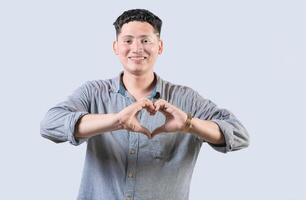 Handsome young man making heart shape with hands isolated. Happy guy making heart shape with hands photo