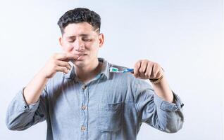 persona con gingivitis participación cepillo de dientes aislado. hombre sufrimiento desde goma dolor participación cepillo de dientes. personas participación cepillo de dientes con goma problema foto