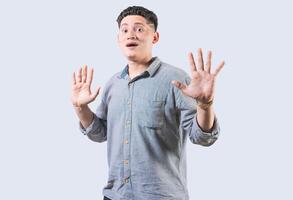 Scared man with raised hands isolated. Young man with scared face with raised hands. Scared and horrified guy with raised palms photo