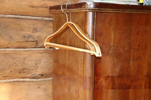 Wooden clothes hangers hang on a retro wooden sideboard in a rustic home. Horizontal photo, close-up photo