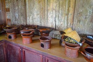 a collection of food containers made of clay containing traditional Javanese food at a buffet restaurant in East Java, Indonesia photo