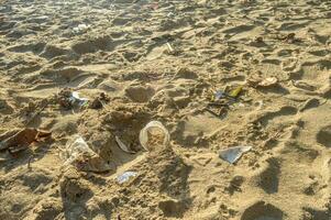 The beach sand is dirty because of plastic mineral water cups photo