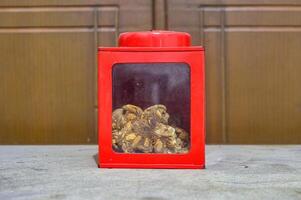 a classic red iron jar with glass showing the snacks inside photo