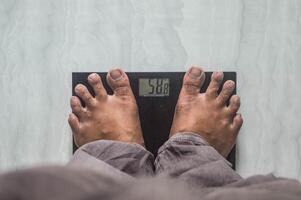 A person weighing himself on a scale can see his feet photo