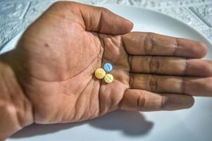 hand carrying three pills for schizophrenic sufferers photo