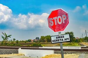 a stop sign with a double track railway track in the background photo