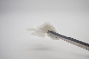 a stainless steel food tong that clamps the tissue isolated on a white background photo