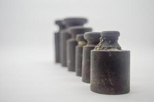 weights ancient scales arranged from small to large isolated on a white background. perfect for economics, finance and business articles photo