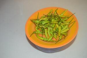 un montón de chiles en un el plastico plato aislado en blanco antecedentes foto