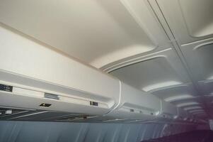 Overhead bin in the aircraft interior for storing passenger luggage photo