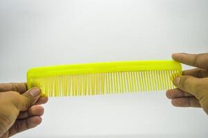 both hands holding a hair comb isolated on white background photo