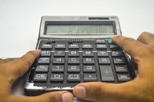 mano calculador utilizando un calculadora aislado en blanco antecedentes. Perfecto para educación, matemáticas, y negocio artículo o contenido. foto