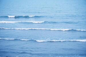 Bluewater waves on the surface ripples blurred. Defocus blurred transparent blue colored clear calm water surface texture with splash and bubbles. Water waves with shining pattern texture background. photo