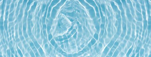 Bluewater waves on the surface ripples blurred. Defocus blurred transparent blue colored clear calm water surface texture with splash and bubbles. Water waves with shining pattern texture background. photo