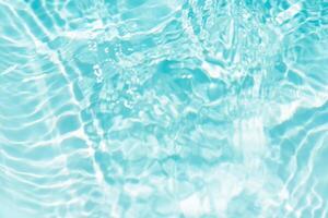 Bluewater waves on the surface ripples blurred. Defocus blurred transparent blue colored clear calm water surface texture with splash and bubbles. Water waves with shining pattern texture background. photo