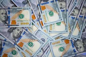 close-up of male hands counting a stack of hundred-dollar US banknotes. a businessman is counting cash. the concept of investment, money exchange, bribes or corruption. selective focus. photo