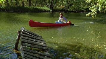 cow-boy dans une canoë flotteurs sur le rivière dans le forêt. historique reconstruction de la vie dans le sauvage Ouest de Amérique. 4k video