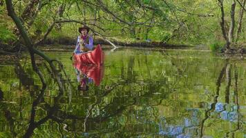 cowboy in een kano drijft Aan de rivier- in de Woud. historisch wederopbouw van leven in de wild west van Amerika. 4k video