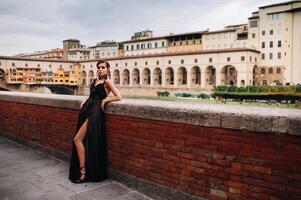 un hermosa elegante novia en un negro vestir camina mediante florencia, un modelo en un negro vestir en el antiguo ciudad de Italia foto