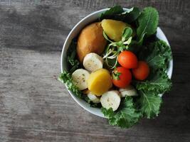 colorful vegetable salad on wood table kale and sunflower sprout photo