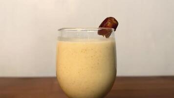 A glass of date milk with dates on top video