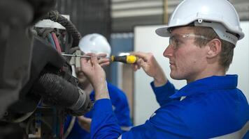 ambos de ingenieros trabajando juntos en un robótico brazo fábrica, robótico brazo industria y Ingenieria concepto. foto