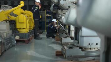 ambos de ingenieros trabajando juntos en un robótico brazo fábrica, robótico brazo industria y Ingenieria concepto. foto