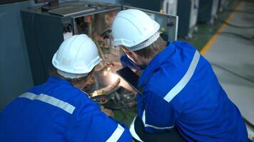 técnico trabajando en el eléctrico controlar gabinete de robótico brazo, robótico brazos industrial antecedentes foto