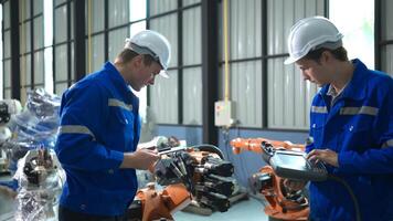 Engineer and technician working with robot arm in factory. Industry and engineering concept. photo