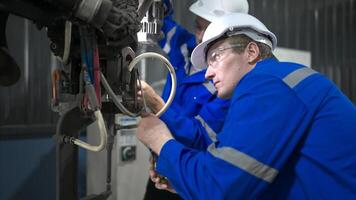 ambos de ingenieros trabajando juntos en un robótico brazo fábrica, robótico brazo industria y Ingenieria concepto. foto