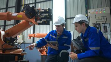 Engineer and technician working with robot arm in factory. Industry and engineering concept. photo