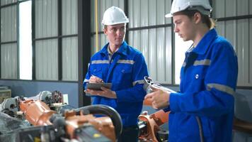 Engineer and technician working with robot arm in factory. Industry and engineering concept. photo