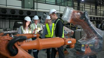 Group of engineers and technicians working together in a robotic arm factory. Inspecting robot arm before delivering to customers photo